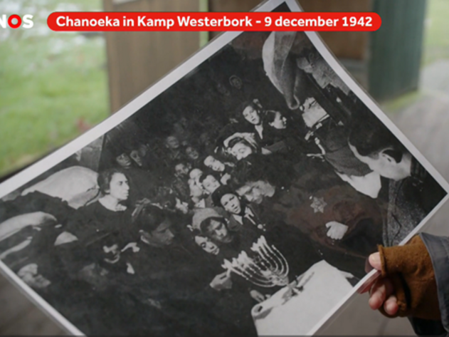 Bertien Minco toont een foto van Chanoeka in december 1942 in Kamp Westerbork - Beeld: NOS